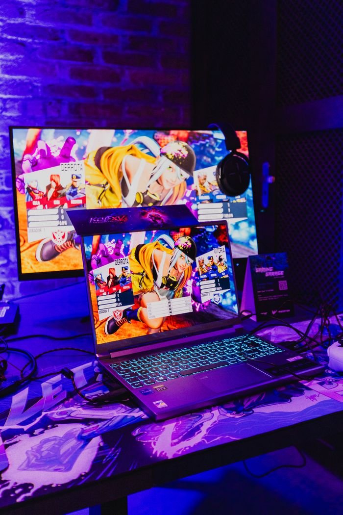 Vibrant gaming setup featuring Predator laptop and monitor displaying a fighting game.