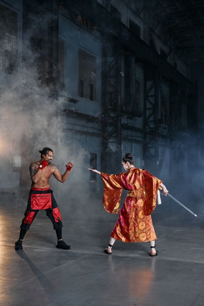 Two fighters in traditional attire face off in a misty dojo setting.